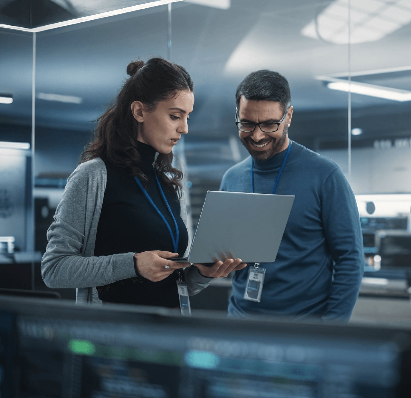 Two people looking at a laptop in a data center